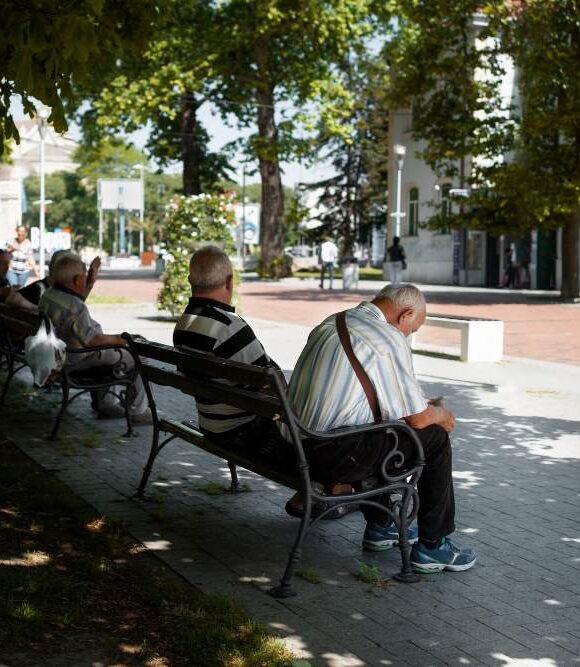 paysage urbain ensoleillé avec hommes assis sur des bancs