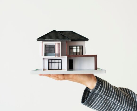 Main tenant une maison Main dans laquelle se trouve une maison à deux étages