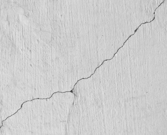 Mur fissuré Mur blanc avec une fissure en diagonale